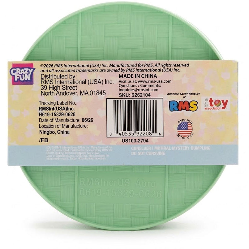 A mint green plastic toy bucket with a cardboard product label attached to the front, photographed against a plain white background.